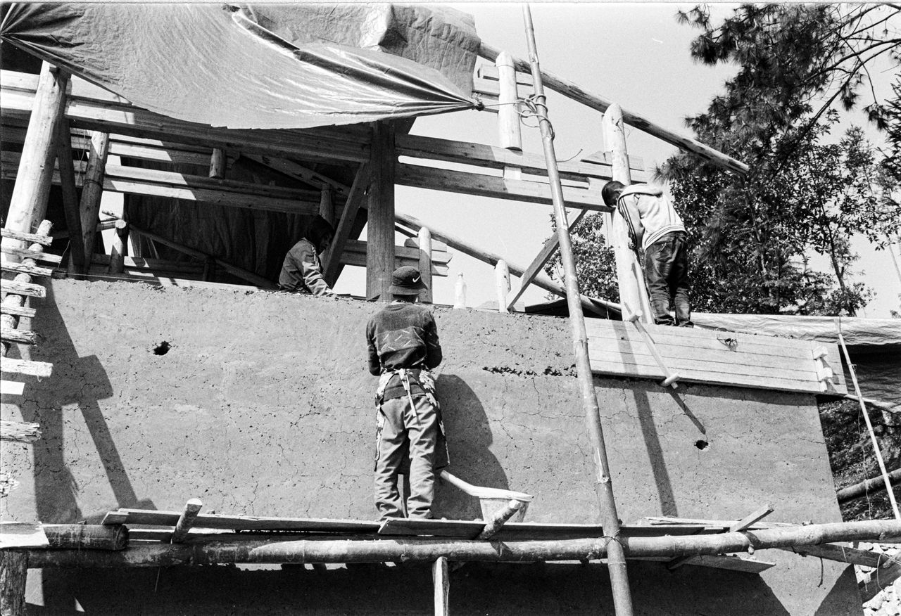 About Monochrome image of workers at a construction site with scaffolding.